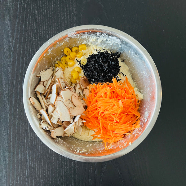 adding the vegetables, hijiki seaweed, and gingko nuts to the tofu mixture