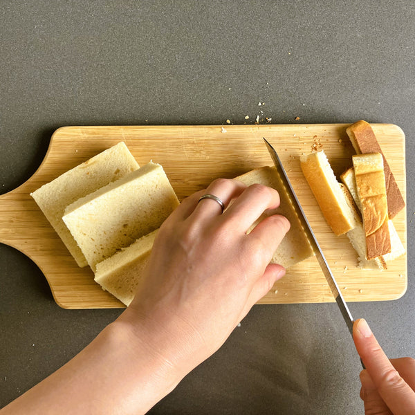 cutting the crusts off of the shokupan