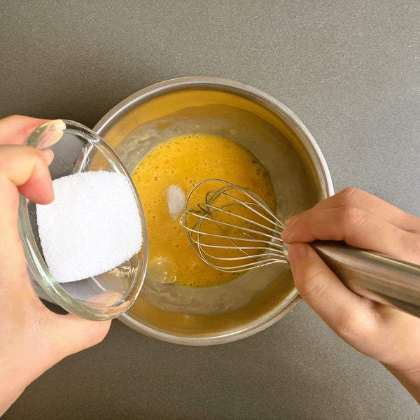 adding sugar to the beaten eggs