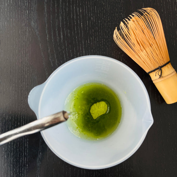 adding hot water to the matcha powder