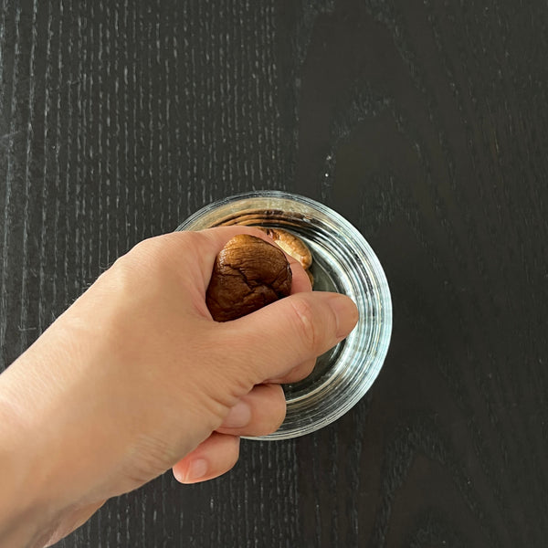squeezing excess water from rehydrated shiitake mushrooms