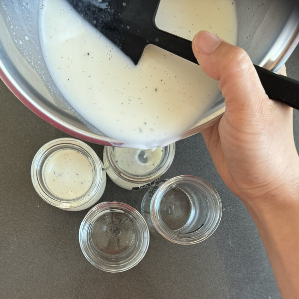 pouring the milk pudding mixture into small jars
