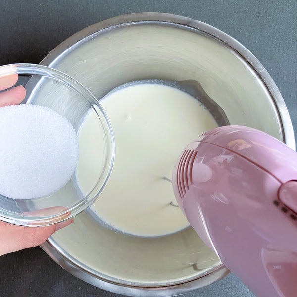 adding the sugar into the whipped cream