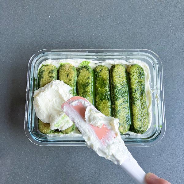 creating a second layer of matcha tiramisu with the ladyfingers and cream
